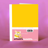 A blue birthday card with a white bunny, dressed in yellow, beside a cake with a lit candle. The text reads "Happy Fucking Birthday!" on a pink background.