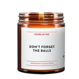 Amber glass candle jar from Virgins On Fire Candle Co., a gay-owned Brooklyn business. Label reads, "Don't Forget the balls." It is a peppermint & eucalyptus scented candle. 